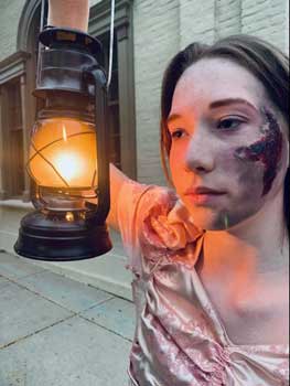 Woman holds lantern.