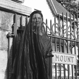 Woman beside cemetery gate
