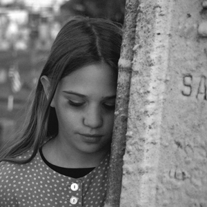 Girl beside gravestone
